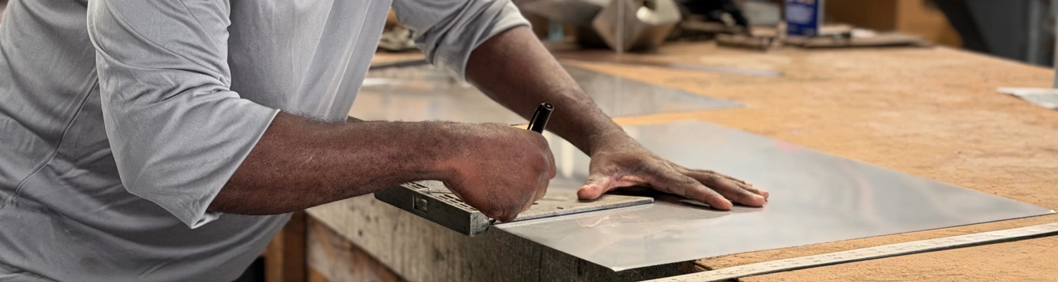 Southern Sheet Metal fabricator measuring and marking custom sheet metal